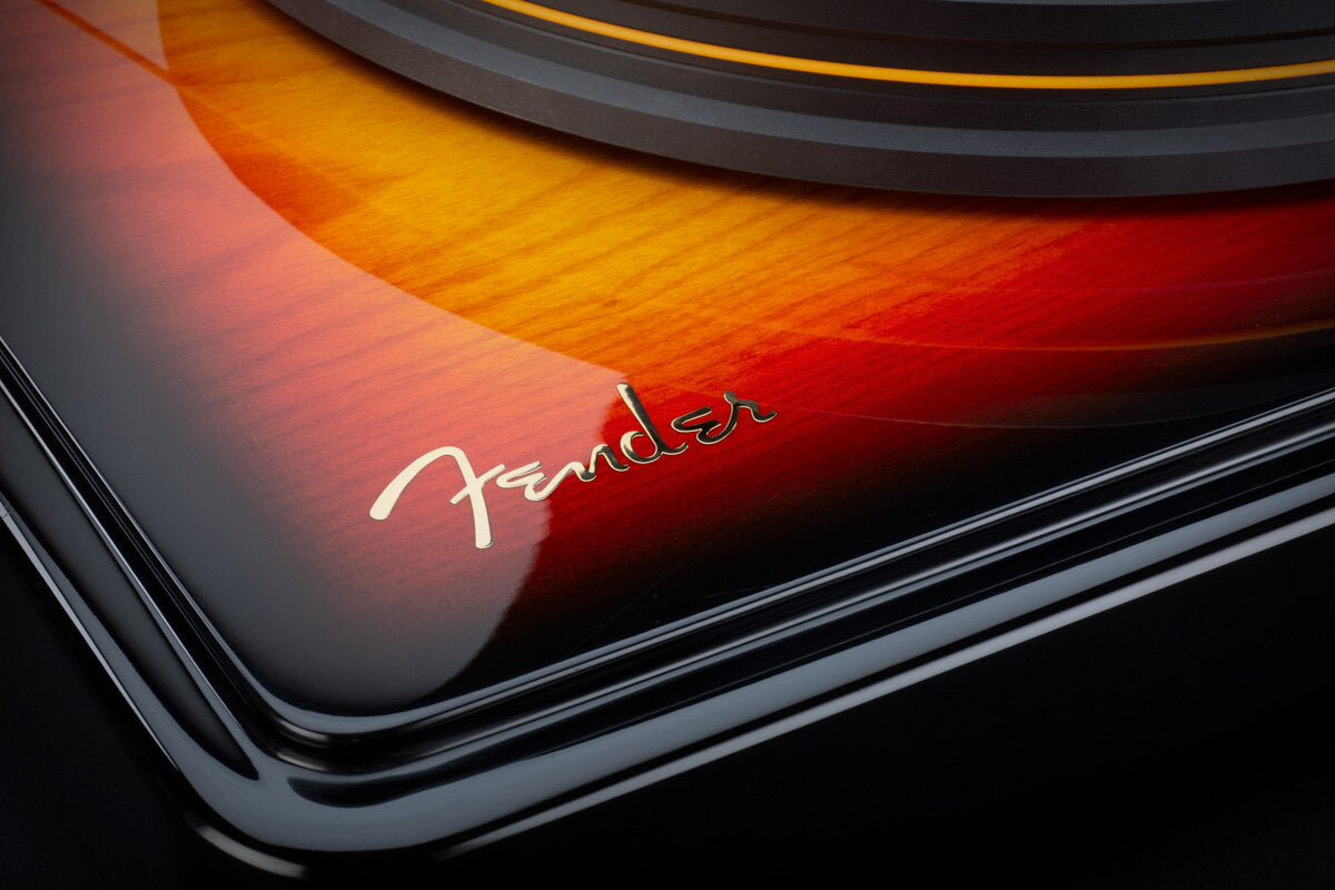 Close up view of Precision Deck's' tricolor finish showing it's rich warm yellow, red and orange hues along with a gold embossed Fender logo emblem. 